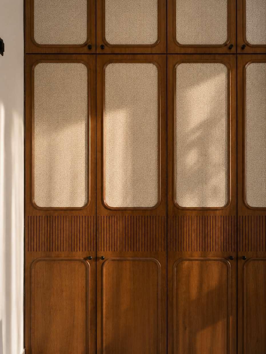 Full-height teak wardrobe with woven cane inset panels and a band of finely fluted timber